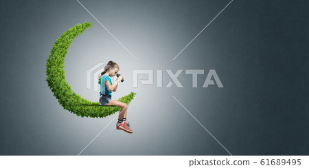 Concept of careless happy childhood with girl on green moon 61689495