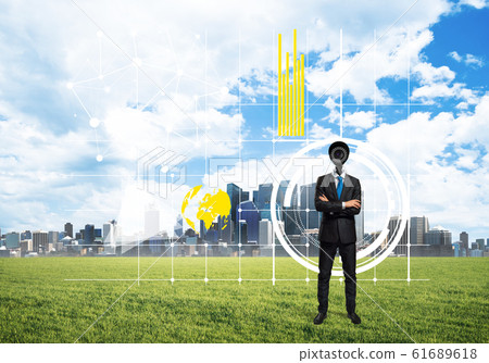 Camera headed man standing on green grass against modern cityscape 61689618