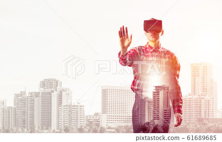 Guy wearing checked shirt and virtual mask stretching hand to to Guy wearing checked shirt and virtual mask stretching hand to to 61689685