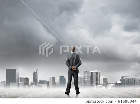 Motivation and inspiration concept with modern cityscape and businessman observing it 61690044