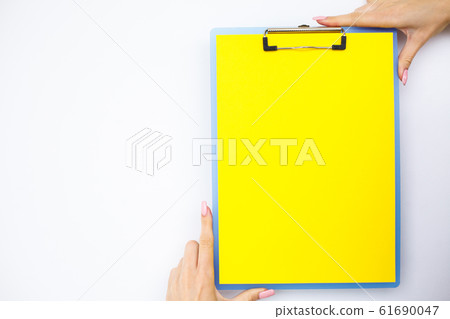 Blank Folder with Yellow Paper. Hand that Holding Folder and Handle on White Background. Copyspace. Place for Text Blank Folder with Yellow Paper. Hand that Holding Folder and Handle on White Background. Copyspace. Place for Text 61690047