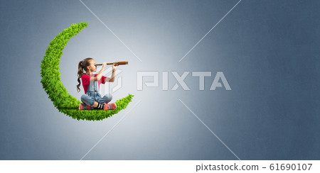 Concept of careless happy childhood with girl on green moon Concept of careless happy childhood with girl on green moon 61690107