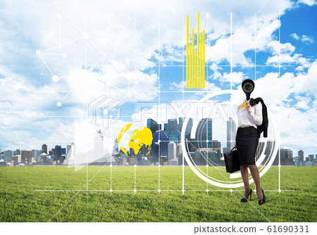 Camera headed woman standing on green grass against modern cityscape 61690331