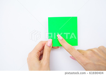 Office Hand Holding a Green Color Sticker on White Background. Copyspace. Place for Text 61690404