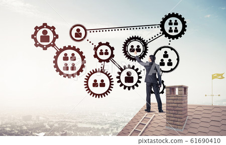 Businessman on house roof presenting teamwork and connection con Businessman on house roof presenting teamwork and connection con 61690410