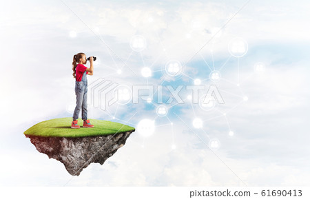 Concept of careless happy childhood with girl looking in binoculars Concept of careless happy childhood with girl looking in binoculars 61690413