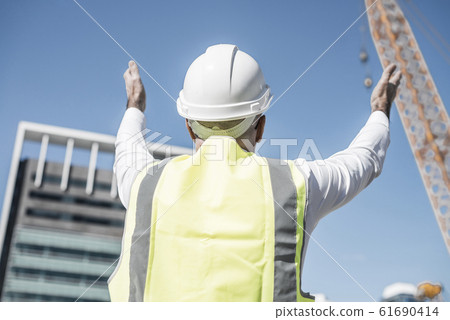 Senior foreman in glasses doing his job at building area on sunn Senior foreman in glasses doing his job at building area on sunn 61690414