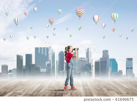 Concept of careless happy childhood with girl looking in binoculars Concept of careless happy childhood with girl looking in binoculars 61690675