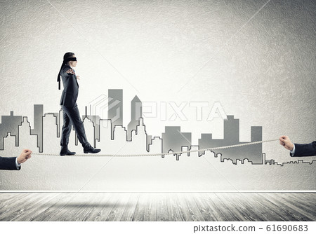 Business concept of risk support and assistance with man balancing on rope Business concept of risk support and assistance with man balancing on rope 61690683