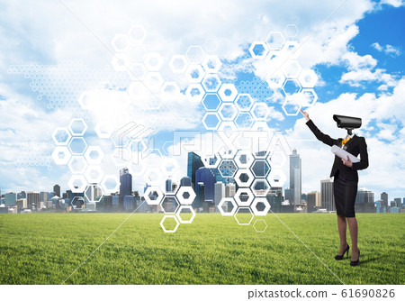 Camera headed woman standing on green grass against modern cityscape Camera headed woman standing on green grass against modern cityscape 61690826