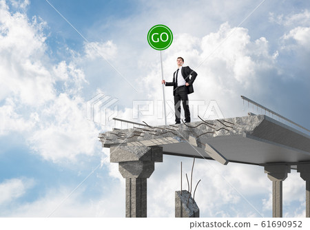 Young businessman holding street safety sign. Young businessman holding street safety sign. 61690952