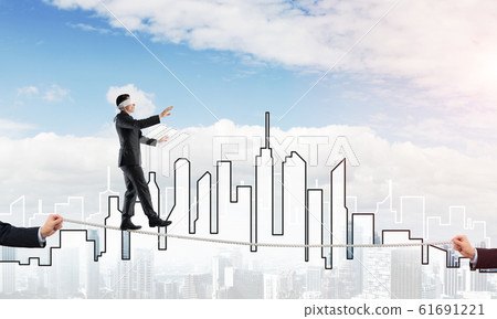 Business concept of risk support and assistance with man balancing on rope Business concept of risk support and assistance with man balancing on rope 61691221