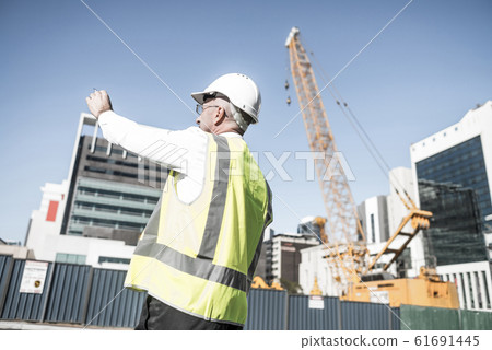 Senior foreman in glasses doing his job at building area on sunn Senior foreman in glasses doing his job at building area on sunn 61691445