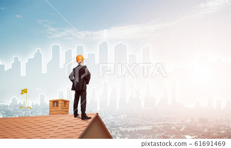 Engineer man standing on roof and looking away. Mixed media Engineer man standing on roof and looking away. Mixed media 61691469
