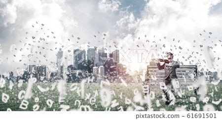 Handsome violinist in park on wooden bench and symbols fly aroun 61691501