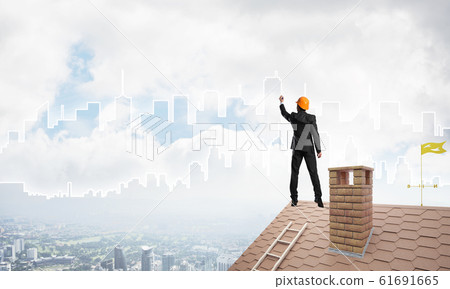 Man architect draw silhouette of modern city on blue sky. Mixed media Man architect draw silhouette of modern city on blue sky. Mixed media 61691665