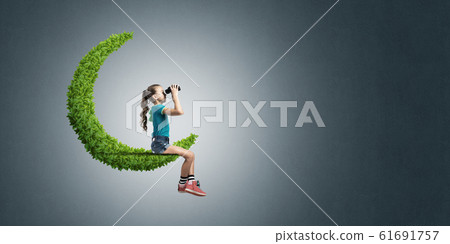 Concept of careless happy childhood with girl on green moon Concept of careless happy childhood with girl on green moon 61691757