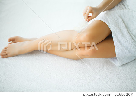 Closeup of a woman showing perfect smooth legs Closeup of a woman showing perfect smooth legs 61693207