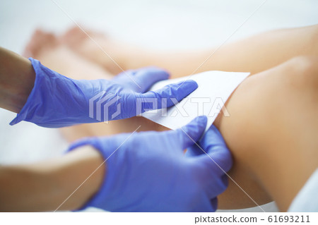 Skin Care. Beautician waxing a woman's leg 61693211