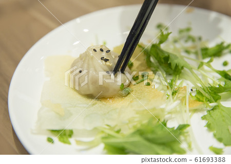 Chopsticks on Xiao Long Pao with vegetable, 61693388