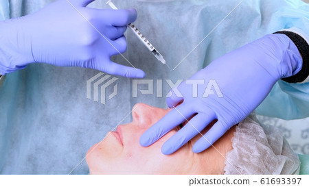 Woman getting cosmetic injection, closeup. Woman in beauty salon. plastic surgery clinic Woman getting cosmetic injection, closeup. Woman in beauty salon. plastic surgery clinic 61693397