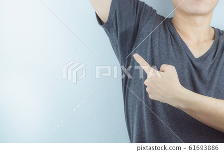 Closeup man with hyperhidrosis sweating very badly under armpit and left stain on his clothes. Closeup man with hyperhidrosis sweating very badly under armpit and left stain on his clothes. 61693886