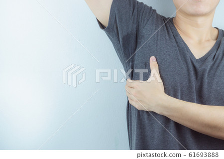 Closeup man with hyperhidrosis sweating very badly under armpit and left stain on his clothes. Closeup man with hyperhidrosis sweating very badly under armpit and left stain on his clothes. 61693888