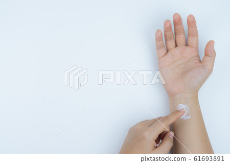 Closeup woman apply pain relief cream on her hand. Health care and medical concept. Closeup woman apply pain relief cream on her hand. Health care and medical concept. 61693891