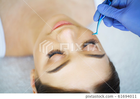 Woman Eye with Long Eyelashes. Eyelash Extension Woman Eye with Long Eyelashes. Eyelash Extension 61694011