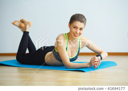 Young yogi attractive woman practicing yoga concept, wearing sportswear, black tank top and pants, full length, white loft background Young yogi attractive woman practicing yoga concept, wearing sportswear, black tank top and pants, full length, white loft background 61694177