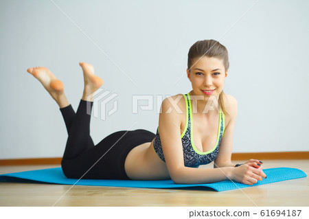 Young yogi attractive woman practicing yoga concept, wearing sportswear, black tank top and pants, full length, white loft background Young yogi attractive woman practicing yoga concept, wearing sportswear, black tank top and pants, full length, white loft background 61694187