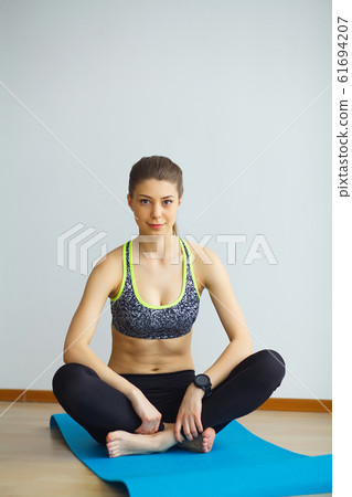 Young yogi attractive woman practicing yoga concept, wearing sportswear, black tank top and pants, full length, white loft background Young yogi attractive woman practicing yoga concept, wearing sportswear, black tank top and pants, full length, white loft background 61694207