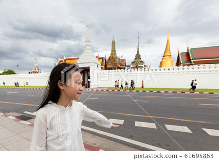 Asian cute girl walking on street of city,Wat Phra Kaew or Wat Phra Si Rattana Satsadaram background,Bangkok,Thailand,travel concept Asian cute girl walking on street of city,Wat Phra Kaew or Wat Phra Si Rattana Satsadaram background,Bangkok,Thailand,travel concept 61695863