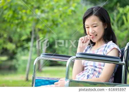 Asian little child girl feeling stressed,worried female bites finger nails in wheelchair outdoor park,girl patient with nervous expression,nail biting,anxious with hand on mouth biting her nails,anxie Asian little child girl feeling stressed,worried female bites finger nails in wheelchair outdoor park,girl patient with nervous expression,nail biting,anxious with hand on mouth biting her nails,anxie 61695897