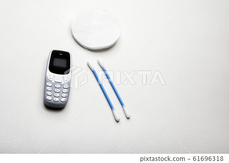 mobile phone ear stick cotton disk leather background mobile phone ear stick cotton disk leather background 61696318