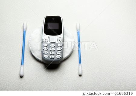 mobile phone ear stick cotton disk leather background mobile phone ear stick cotton disk leather background 61696319