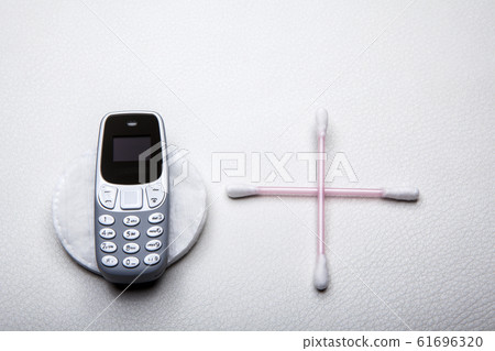 mobile phone ear stick cotton disk leather background mobile phone ear stick cotton disk leather background 61696320