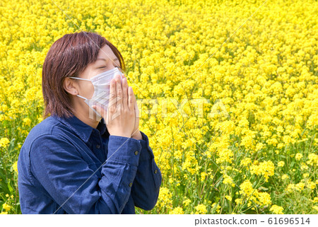 A woman wearing a mask holding her mouth in a rape field 61696514