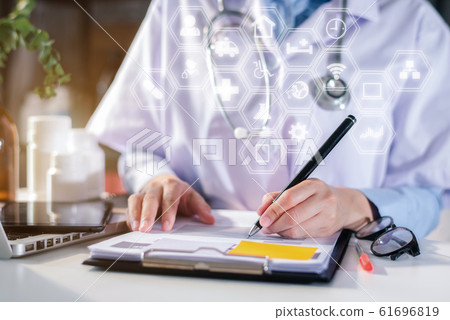 Female doctor working on desk with laptop computer and paperwork in the office. Medical and doctor concept. Female doctor working on desk with laptop computer and paperwork in the office. Medical and doctor concept. 61696819
