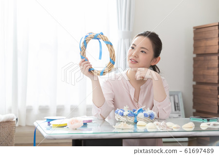 Woman making summer wreath Woman making summer wreath 61697489