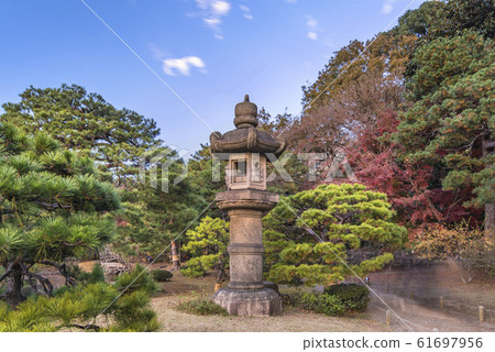 A huge stone lantern standing next to Tazuru Bridge in Rikugien Garden in Komagome in autumn. A huge stone lantern standing next to Tazuru Bridge in Rikugien Garden in Komagome in autumn. 61697956