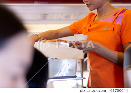 Flight attendant serving drinks to passengers on board. Flight attendant serving drinks to passengers on board. 61700044