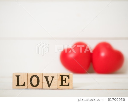 Close up at the word LOVE, love on wooden cube with blurred red heart background. Use for valentines day, love and relationship concept. 61700950