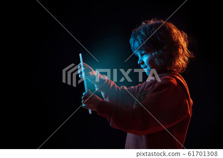 Caucasian boy's portrait isolated on dark studio background in neon light Caucasian boy's portrait isolated on dark studio background in neon light 61701308