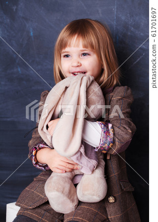 Cute Happy little girl hugging her toy rabbit 61701697