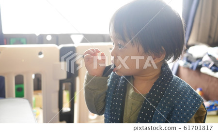 One-year-old child biting the sleeve of clothes One-year-old child biting the sleeve of clothes 61701817