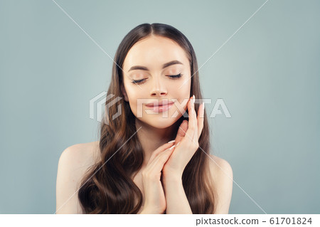 Beautiful woman touching her skin her hand on blue Beautiful woman touching her skin her hand on blue 61701824