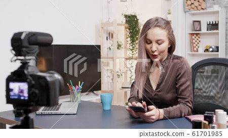 Beauty influencer laughing and smiling while reading questions from her followers 61701985