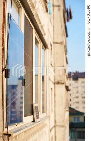 Solar battery on the window of a high-rise residential building, urban blurred background Solar battery on the window of a high-rise residential building, urban blurred background 61701990