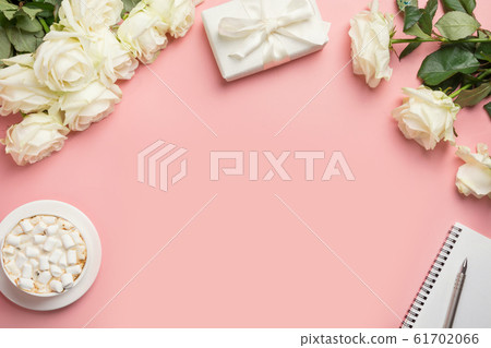 Woman workspace with white roses, gift, coffee Woman workspace with white roses, gift, coffee 61702066